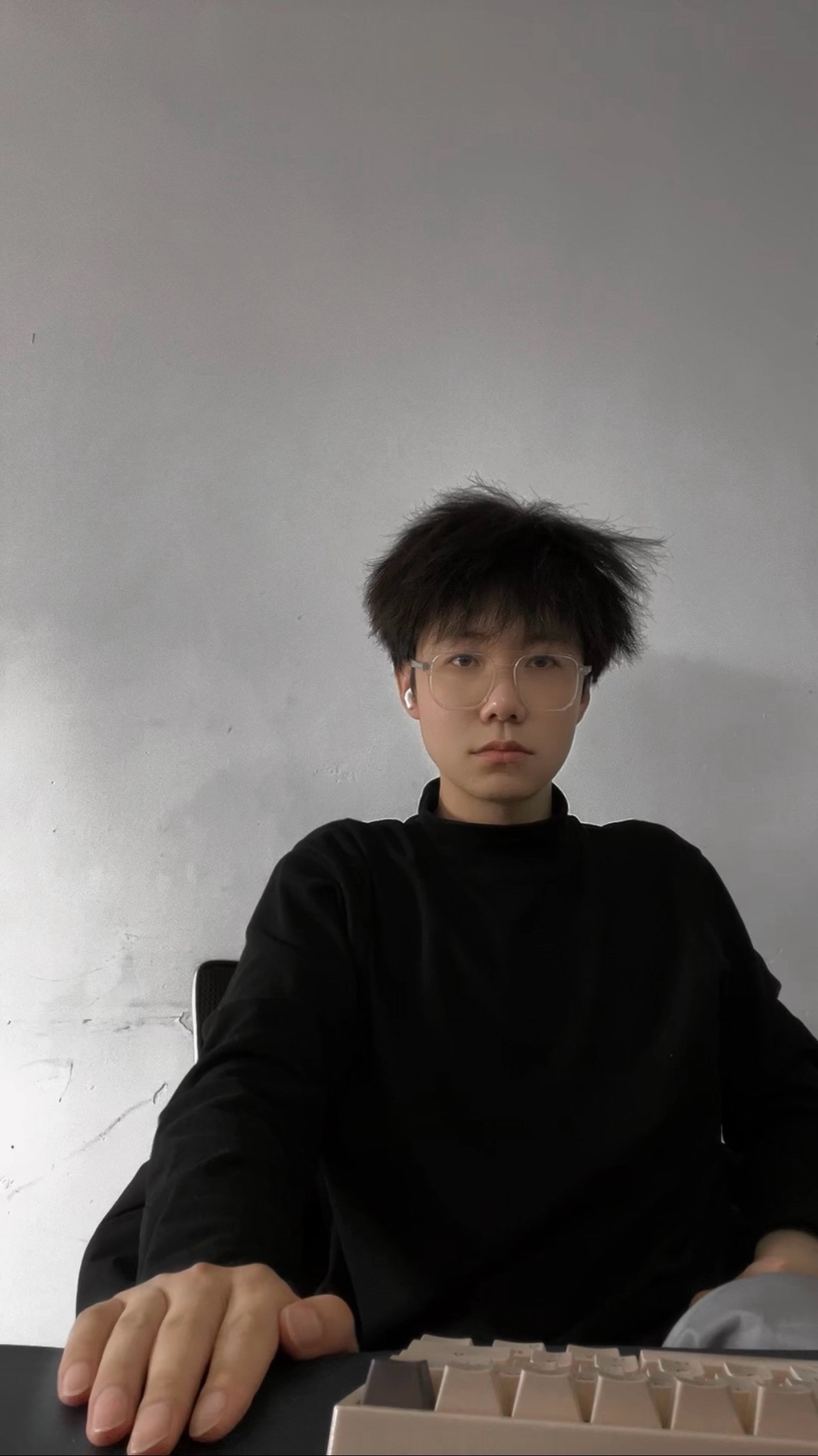 SHAN 坐在工作台前敲代码的照片